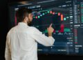Analysts discussing crypto compliance data on digital screens at a conference.