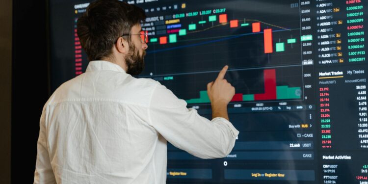 A financial analyst examines cryptocurrency charts on a digital screen with graphs and data.
