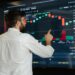 A financial analyst examines cryptocurrency charts on a digital screen with graphs and data.