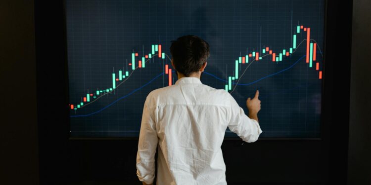 A trader analyzes Bitcoin charts on a digital screen with financial data and graphs visible.