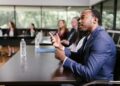 A group of bankers discussing cryptocurrency regulations around a conference table.