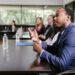 A group of bankers discussing cryptocurrency regulations around a conference table.