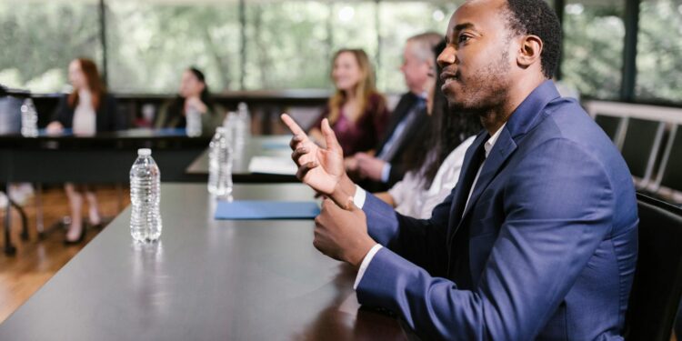 A diverse group of professionals discussing AI policy at a conference table.