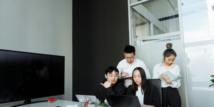 Allbirds team brainstorming over laptops, discussing AI technology for business solutions.