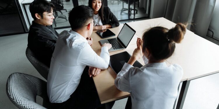 Employees in an office discussing restructuring and job cuts at a tech startup.