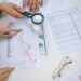 Office workers reviewing financial reports with graphs reflecting declining revenue trends.