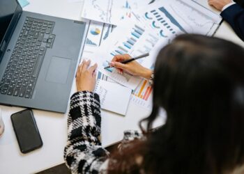 A business professional analyzing cryptocurrency regulations at a desk with financial reports.