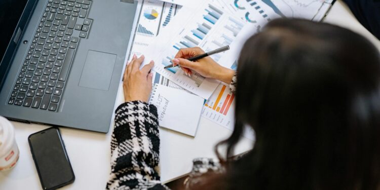 A business professional analyzing cryptocurrency regulations at a desk with financial reports.