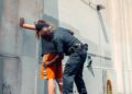 Police arresting a man in a financial office, raising compliance worries.