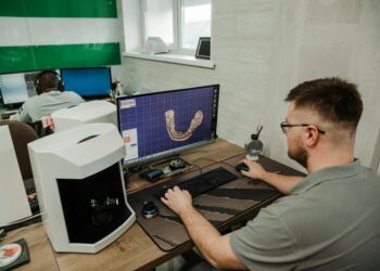 A technician analyzes gemstones with advanced AI software in a lab setting.