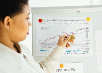 A financial analyst reviews charts and reports on cryptocurrency investments.