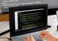 A developer using a laptop to code a personal data scrubber tool on a digital screen.