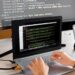 A developer using a laptop to code a personal data scrubber tool on a digital screen.