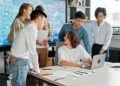 A group of diverse creators discussing blockchain projects in a collaborative workspace.