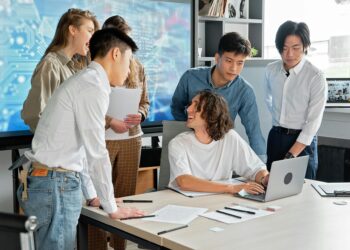 A group of diverse creators discussing blockchain projects in a collaborative workspace.