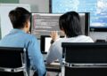 Aave developers discussing strategies for improving rsETH collateral ratio on digital screens.