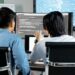 Aave developers discussing strategies for improving rsETH collateral ratio on digital screens.
