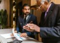 Finance professionals discuss IPO plans at a conference table with charts and documents.
