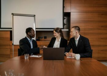 Microsoft and OpenAI executives discuss partnership adjustments over a conference table.