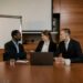 Microsoft and OpenAI executives discuss partnership adjustments over a conference table.