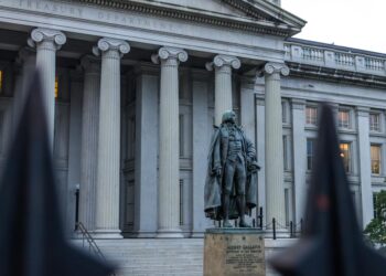 US Treasury building with cryptocurrency symbols, highlighting new AML regulations for stablecoins.