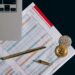 A Bitcoin coin alongside financial documents and a regulatory book on a desk.