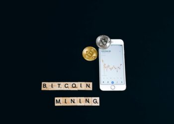 Bitcoin mining hardware with a fluctuating cryptocurrency price chart in the background.