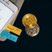 A person checks cryptocurrency prices on a smartphone with financial documents beside it.