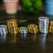 Stacks of coins and digital currency icons illustrating stablecoins and crypto regulations.