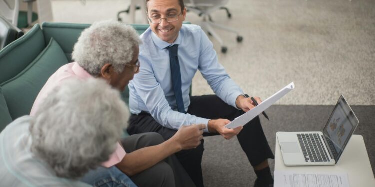 A financial advisor discusses cryptocurrency with clients in a modern office setting.