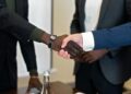 Coreweave and Anthropic executives shaking hands in an office setting, symbolizing partnership.