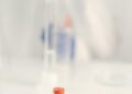 Vaccination research laboratory with scientists studying vaccine data and responses.