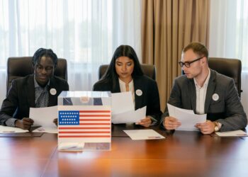 A group of officials discussing cryptocurrency regulations at a conference table.