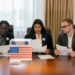 A group of officials discussing cryptocurrency regulations at a conference table.