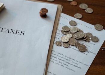 Close-up of stablecoin coins with tax documents and a gavel on a desk, symbolizing financial regulation.