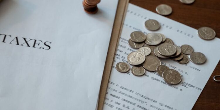 Close-up of stablecoin coins with tax documents and a gavel on a desk, symbolizing financial regulation.