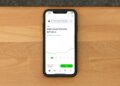 A smartphone displaying Robinhood and OpenAI logos with financial charts in the background.