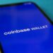 A user interacts with a smartphone displaying the Coinbase app and USDC cryptocurrency.
