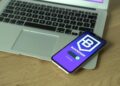 A smartphone displaying a fake Ledger Live app with a bitcoin balance dwindling to zero.