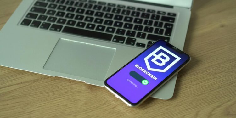 A smartphone displaying a fake Ledger Live app with a bitcoin balance dwindling to zero.