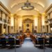 Congress members debating in chamber, emphasizing foreign policy and military presence.