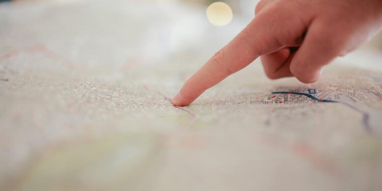 Trump gestures during a speech, outlining US withdrawal plans from Iran with a map beside him.