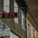A courthouse with a cryptocurrency exchange logo, symbolizing legal battles in finance.