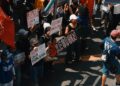 People rallying with signs advocating for cryptocurrency regulation reforms.