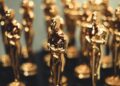 Red carpet at Oscars with film industry professionals discussing AI content regulations.