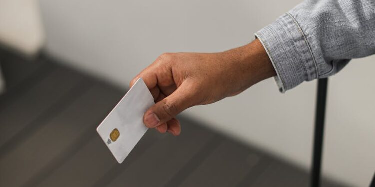 Hand holding a sleek corporate card with a digital interface showcasing financial data.