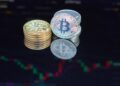 Bitcoin coins stacked with a backdrop of digital graphs and mining equipment.