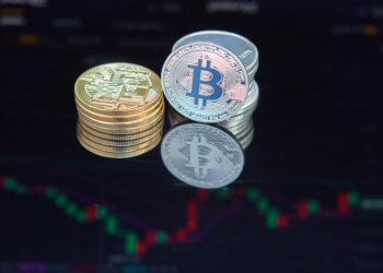 Bitcoin coins stacked with a backdrop of digital graphs and mining equipment.