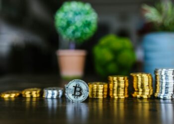 Stacks of cryptocurrency coins with US Treasury emblem in the background.